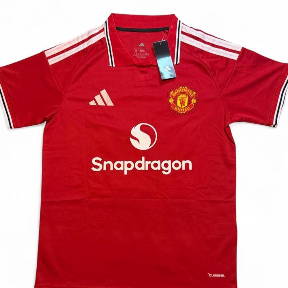 Adidas Manchester United 2026/27 home shirt in red with white stripes on shoulde